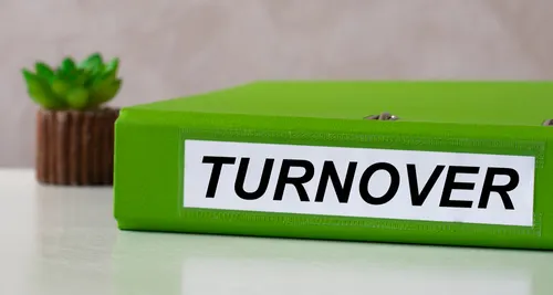 Green binder labeled turnover on a desk, representing an apartment turnover checklist for property management.